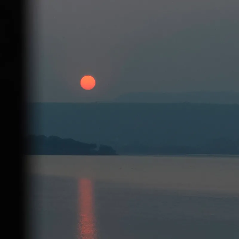 Crimson embers dancing upon a silent, silver lake.